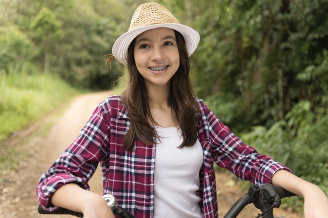 Girl with braces riding a bike outdoors | Orthodontist in Tomball, TX