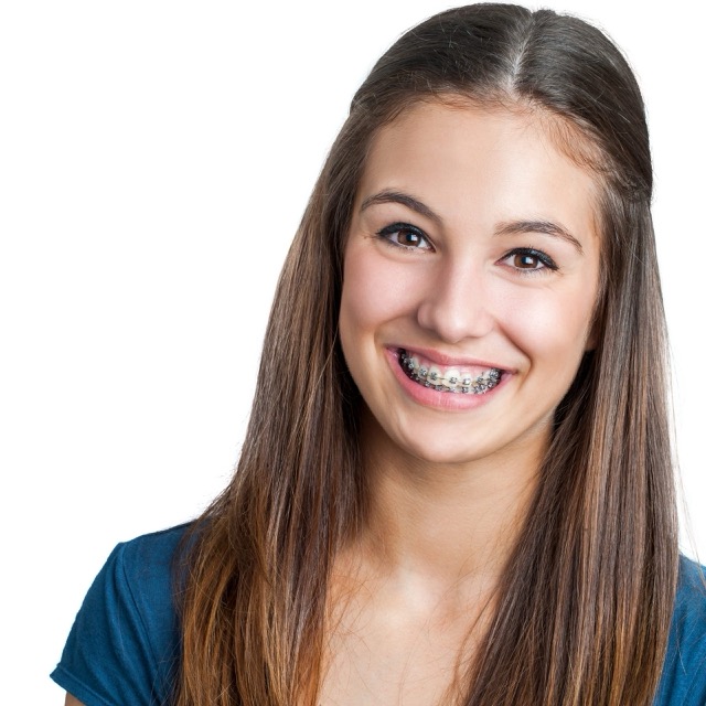 Teen girl with braces smiling against white background | Orthodontist in Tomball, TX